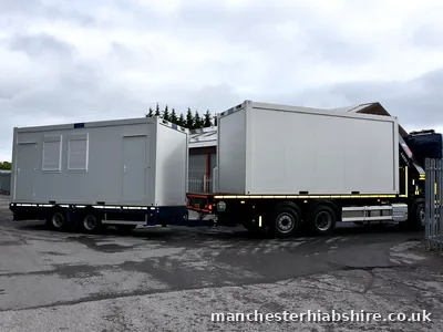 Wagon and drag HIAB outfit in full side profile loaded with two cabin units