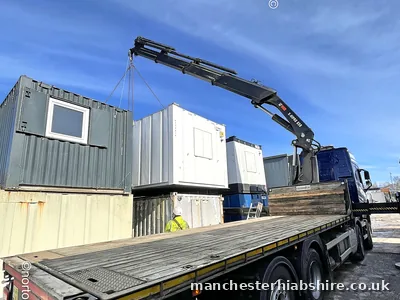 Wagon and drag HIAB lifting a cabin from the trailer
