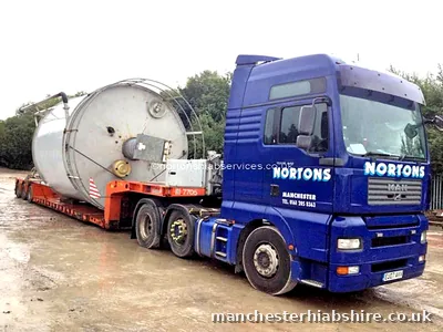 Large stainless vessel on a low loader marked as a wide load
